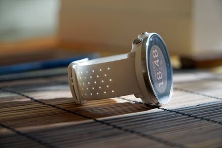 Sport watch in white color on wooden table, Smart watch for running and fitness trainingの写真素材