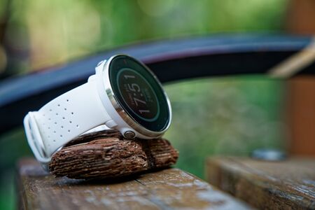 Close-up sport watch for running white color on wooden bench. Fitness watch for tracking daily activity and power trainingの写真素材