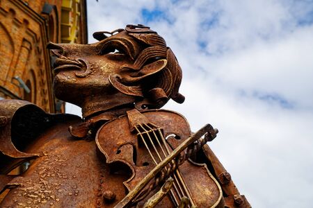 Face of an old rusty statue with iron violin.の写真素材
