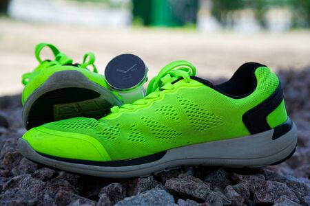 Sport watch for crossfit and triathlon on the green running shoes. Smart watch for tracking daily activity and strength trainingの写真素材