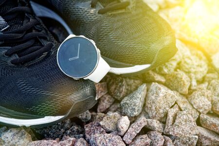 Sport watch for crossfit and triathlon on the running shoes. Smart watch for tracking daily activity and strength training. Sun beam lightsの写真素材
