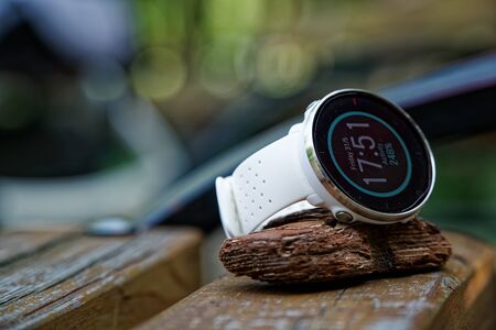 Close-up sport watch for running white color on wooden bench. Fitness watch for tracking daily activity and power trainingの写真素材