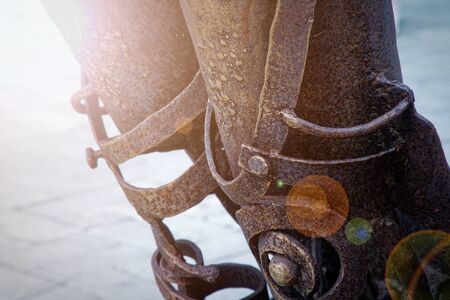 Weathered rusty metal element on the street, shaped detail closeup. Grunge rusty metal texture. Rough dirty surface of metal decorationの写真素材