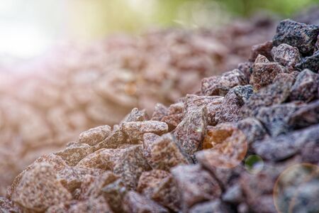 Road gravel and granite gravel texture. Crushed Gravel background. Pile of Stones texture. Industrial coals. Sun beam lights.の写真素材