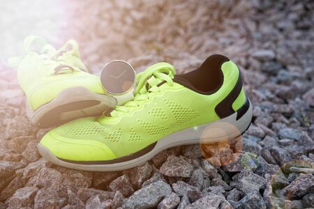 Sport watch for crossfit and triathlon on the yellow running shoes. Smart watch for tracking daily activity and strength training. Sun beam lights.の写真素材