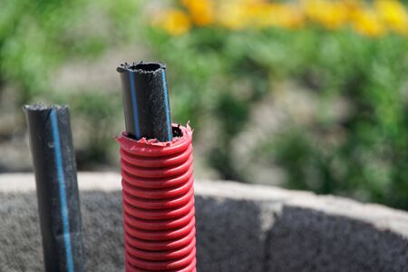 Communication cable outdoor, laying a fiber optic cable for fast internet, Electricity and telephone cable along a new street. Cable Installation power lines at city street, industrial electricity and communication concept.の写真素材