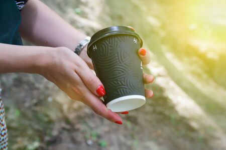Female hand with black paper cup of coffee take away.の写真素材