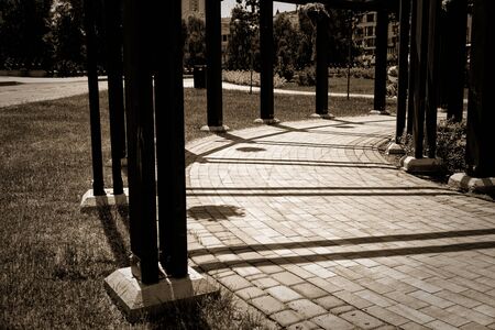 Tunnel of wooden pillars and pots of flowers, gazebo in the park.の写真素材