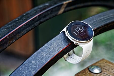 Sport watch for running white color on wooden bench. Fitness watch for tracking daily activity and power trainingの写真素材