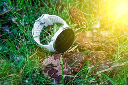 Sport watch for running white color on the ground in the grass. Fitness watch for tracking daily activity and strength trainingの写真素材