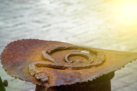 Weathered rusty metal element on the street, shaped detail closeup. Grunge rusty metal texture. Rough dirty surface of metal decorationの写真素材