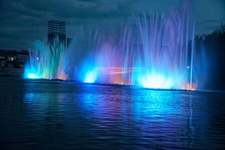 Colorful water fountains with laser and light reflection over lake.の写真素材