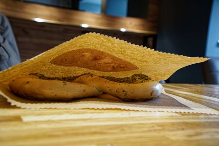 Pretzels in paper pack on wooden table.の写真素材
