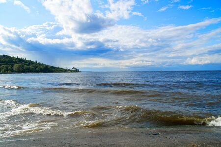 Surging wave on the Kyiv sea reservoir, water reflection, foam and sun beam.の写真素材