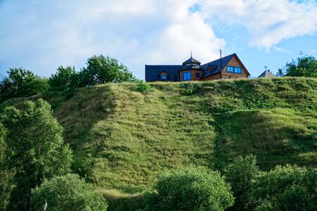 Wooden cottage in the valley, cozy house, cloudy weather.の写真素材