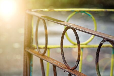 Rusty iron fence with damaged steel circlesの写真素材