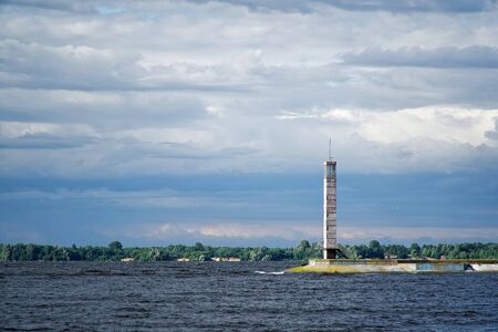 Lighthouse or old beacon under storm clouds.の写真素材
