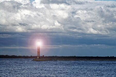 Lighthouse or old beacon under storm clouds.の写真素材