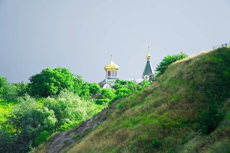 Little church with domes on top of the hill, cloudy weather.の写真素材