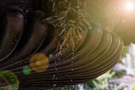 Fountain in the sun backlight. The fountains gushing sparkling water from pipe in park.の写真素材