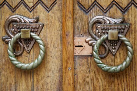 Doorknocker close-up, details of old wooden door.