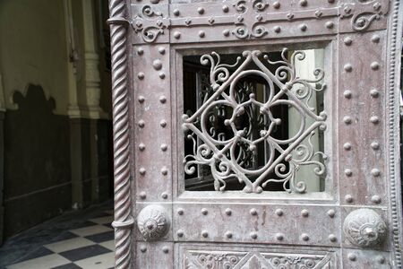 Door with metal decoration. Ornament twirly metal fittings on ancient medieval doorの写真素材