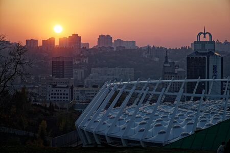 Stadium construction. Aerial view of the stadium roof on the city's background. Sunset behind stadium for soccer.の写真素材