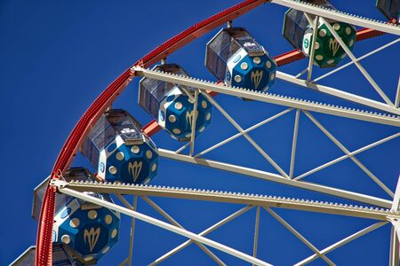 Carousel. Ferris Wheel on a blue background. Carriages of the big wheel.の写真素材