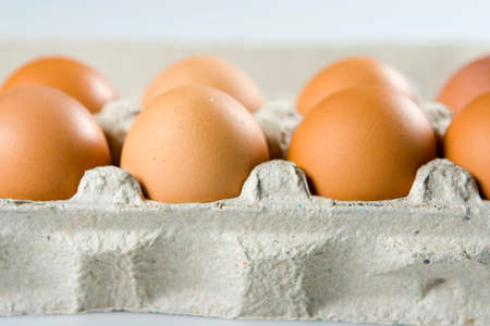 Several brown fresh eggs in grey container, close-up
