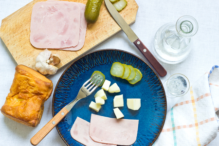 Vodka, salty cucumbers, cheese and ham as appetizerの写真素材