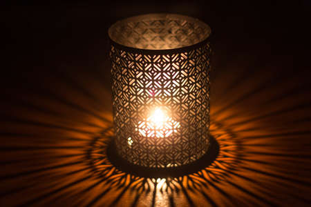 Candle in sconce with lacing effect and games of shadowsの写真素材