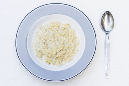 Porridge served in plate with spoon close upの写真素材