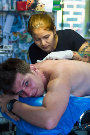 HUA HIN, THAILAND - MARCH 09, 2016: Modern tattoo workshop of  professional artist working with male client, Prachuap Khiri Khan Provinceのeditorial素材