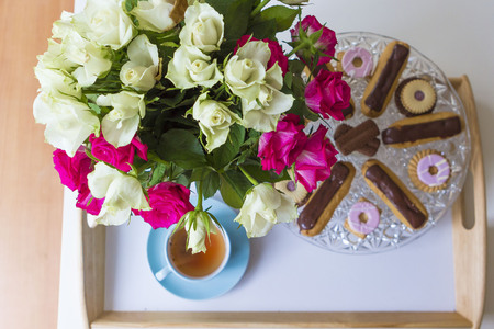Still life with cup of tea, sweets and rosesの写真素材
