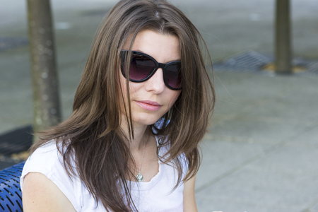 Portrait of young brunette in sunglasses outdoorsの写真素材
