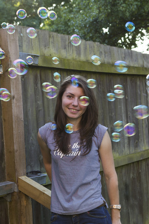 Young woman with soap bubbles in summer evening