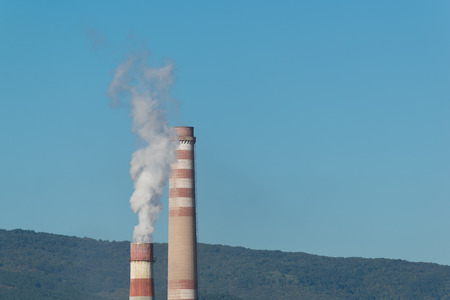 Industrial smokestack on blue sky