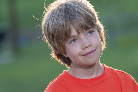 Portrait of a young boy in park with blurred backgroundの写真素材