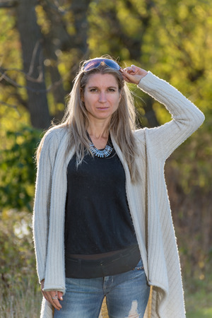 Attractive blonde young woman in a park with blurred backgroundの写真素材