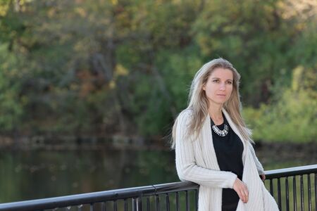 Attractive blonde young woman in a park with blurred backgroundの写真素材