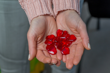 Close up of woman hands holding a red heartsの写真素材