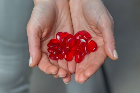 Close up of woman hands holding a red heartsの写真素材