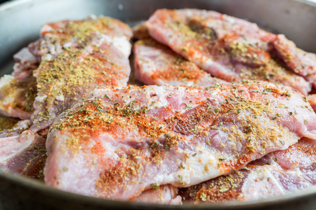Uncooked pork steaks with seasoningの写真素材