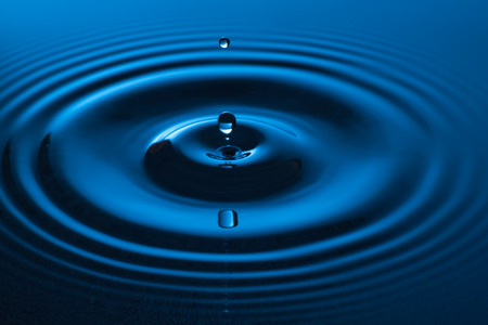 Water drop falling into water making a concentric circles