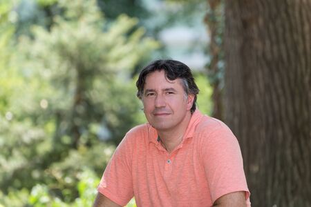Portrait of a handsome man in park, with blurred backgroundの写真素材