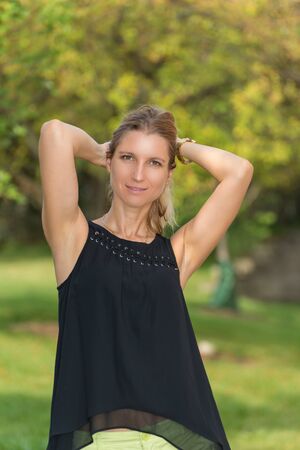 Attractive blonde young woman in a park with blurred backgroundの写真素材