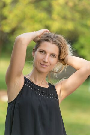 Attractive blonde young woman in a park with blurred backgroundの写真素材