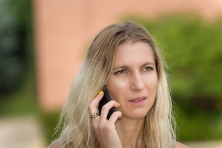 Worried woman receiving bad news over the phoneの写真素材