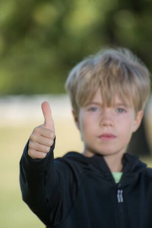 A kid giving a thumb up symbolの写真素材