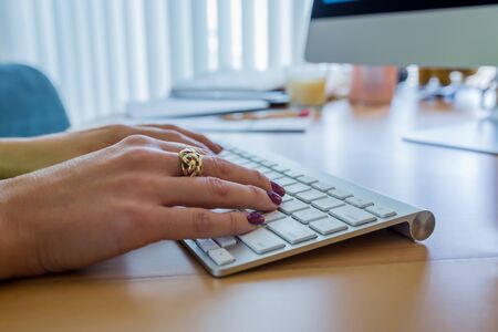 Female hands typing on a computer keyboardの写真素材